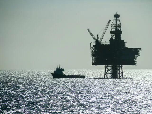 NORTH SEA, NORWAY - 2011 APRIL 23. Silhouette of an Offshore Supply Vessel alongside oil platform Ringhorn in the North Sea